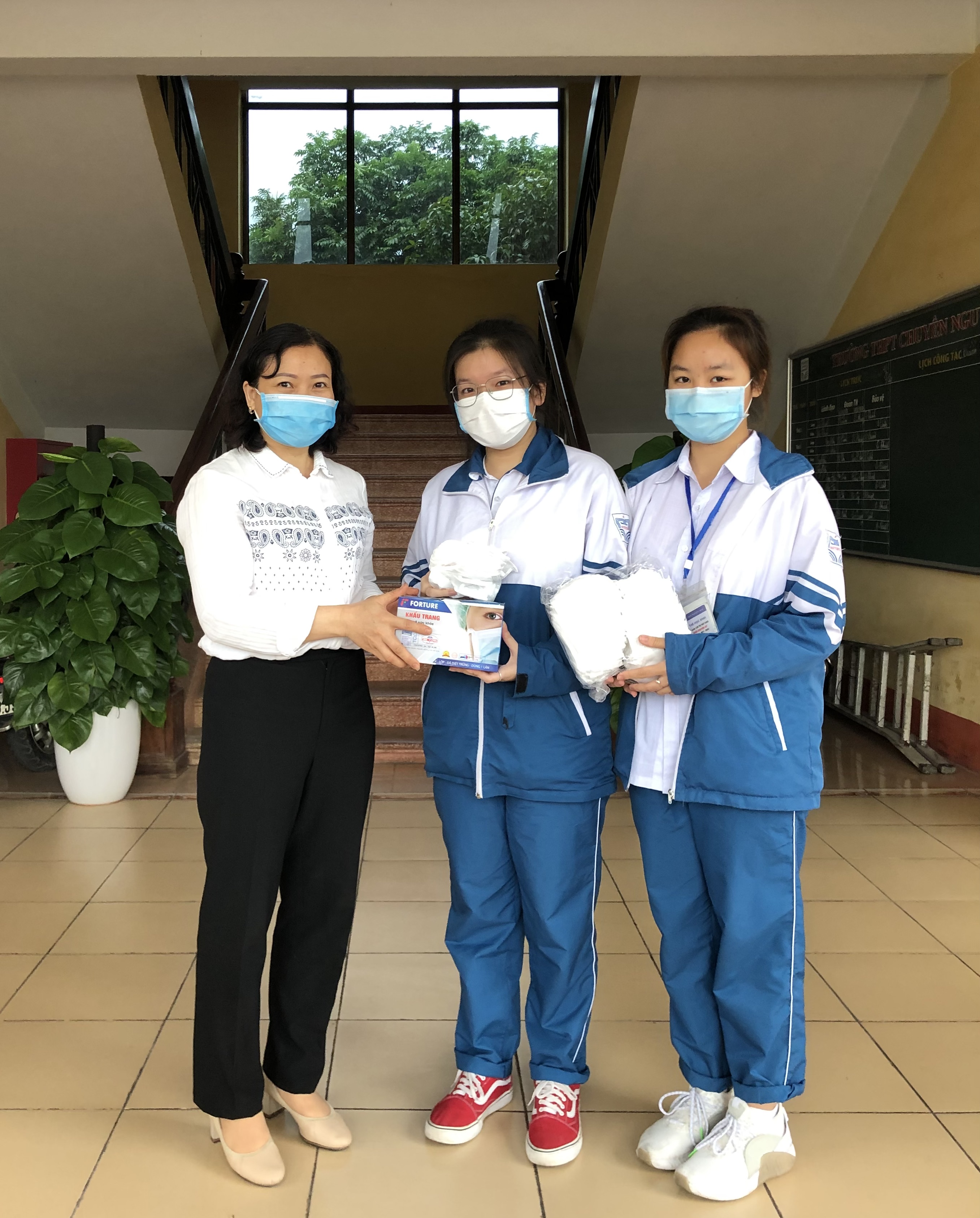 Cô Ngô Thị Hương – cán bộ y tế nhà trường phát khẩu trang cho học sinh khối 12
